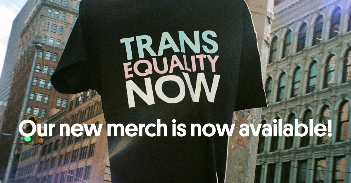 A photo of a black t-shirt that says Trans Equality Now afloat in a city. Across the bottom is the text Our New Merch is Now Available.