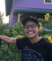 Alex wearing cap in front of sunflowers